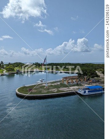Boca Chita Harbor with boats, palm trees, and calm waters under a blue sky. Boca Chita Harbor with boats, palm trees, and calm waters under a blue sky. 143206119