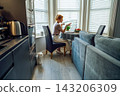 Middle aged woman has video conference call on laptop and drink coffee at kitchen table. Female entrepreneur working remotely, has online e-learning course at home. freelance concept. . Online Job. 143206309