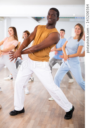 Group of different people rehearsing dance in dance studio Group of different people rehearsing dance in dance studio 143206564