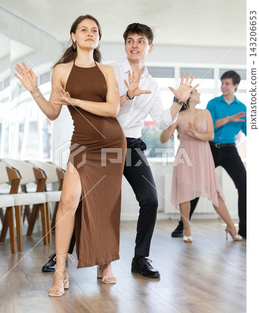 Dancing in a dance studio - couple in festive clothes learning to dance foxtrot Dancing in a dance studio - couple in festive clothes learning to dance foxtrot 143206653