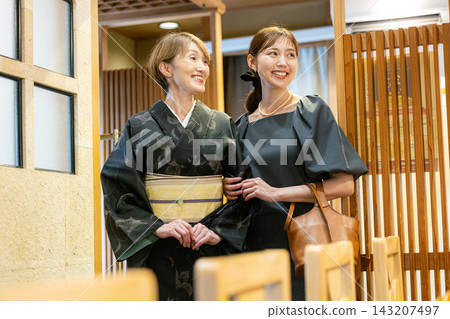 一位家長帶著孩子從入口進入壽司店。 一位家長帶著孩子從入口進入壽司店。 143207497