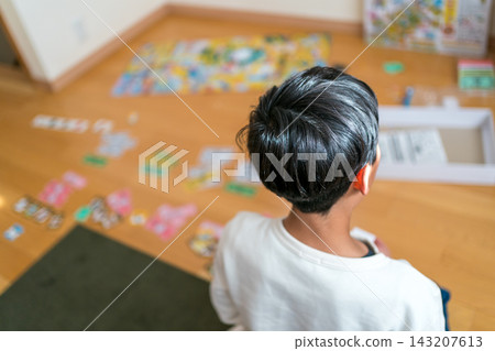 一個男孩在玩桌遊，背影清晰可見。 143207613