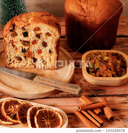 Traditional panettone with candied fruit and raisins, sliced for a Christmas dessert, with festive decoration. 143208476