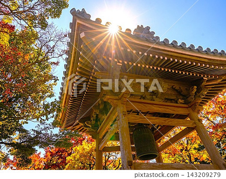 The temple bell tower and sunshine surrounded by autumn foliage The temple bell tower and sunshine surrounded by autumn foliage 143209279