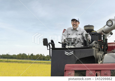 Senior man driving a combine harvester Senior man driving a combine harvester 143209862