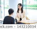 一位面帶微笑的女士在休息室遞給顧客一張名片。 143210034