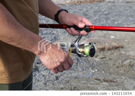At hand of a man fishing At hand of a man fishing 143211054