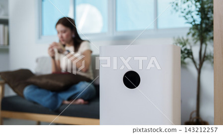 White air purifier operating in living room for indoor air quality and allergy relief White air purifier operating in living room for indoor air quality and allergy relief 143212257