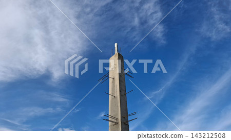 Single Concrete Column Standing High Under Soft Blue Clouded Sky Single Concrete Column Standing High Under Soft Blue Clouded Sky 143212508