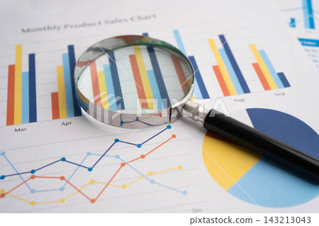 Magnifying glass on data business graphs paper. Magnifying glass on data business graphs paper. 143213043