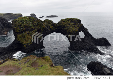 The iconic Gatklettur rock arch extending into the sea at Arnarstapi, Iceland The iconic Gatklettur rock arch extending into the sea at Arnarstapi, Iceland 143213621