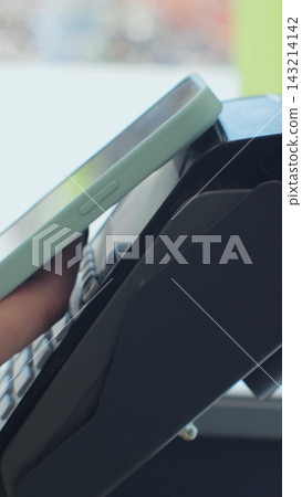 Vertical video. Young woman customer making contactless payment in supermarket store. 143214142