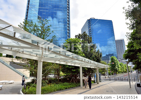 一名女子走過濱松町站新建的行人通道，抬頭望向單軌列車。 143215514