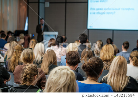 Audience facing a male speaker at a lectern Audience facing a male speaker at a lectern 143215594