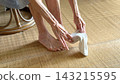 An elderly woman putting her toes into a sock. 143215595
