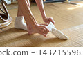 An elderly woman putting on socks 143215596