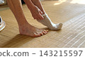 The hands of elderly women pulling when putting on socks 143215597
