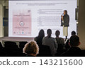 Audience silhouettes against an illuminated presentation screen 143215600