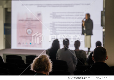 Audience silhouettes against an illuminated presentation screen Audience silhouettes against an illuminated presentation screen 143215600