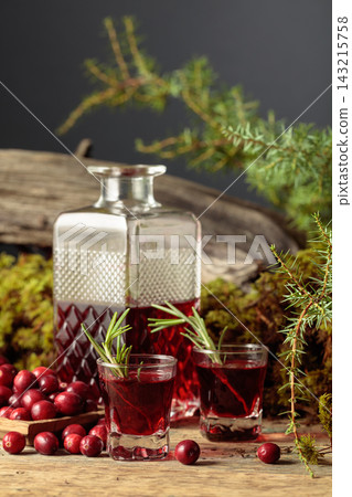 Cranberry liquor on an old wooden table. 143215758