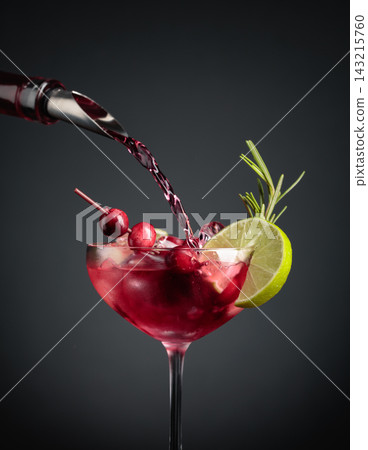 Cranberry cocktail garnished with berries, lime, and rosemary. Cranberry cocktail garnished with berries, lime, and rosemary. 143215760