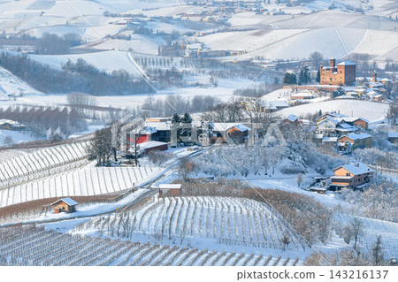 Winter countryside scene with snow-covered vineyards on the hills and a small village in Italy. Winter countryside scene with snow-covered vineyards on the hills and a small village in Italy. 143216137