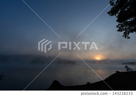 Blue morning mist envelops Lake Shumarinai at dawn. Blue morning mist envelops Lake Shumarinai at dawn. 143216233