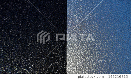 Macro close up of wet textured metal surface with water droplets on split blue and black background, showing rough grain pattern in moody contrast Macro close up of wet textured metal surface with water droplets on split blue and black background, showing rough grain pattern in moody contrast 143216813