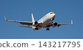 The plane lands, passenger airliner. The plane lands. Airplane, passengers flying in the blue sky, preparing to land at the airport 143217795