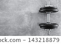 Dumbbell on gray concrete background 143218879