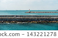 Lighthouse by the Sea with Stone Breakwater 143221278