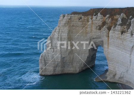 La Manneporte chalk cliff at Alabaster Coast. Étretat, France. Ocean view landscape, tourism and traveling to Normandy La Manneporte chalk cliff at Alabaster Coast. Étretat, France. Ocean view landscape, tourism and traveling to Normandy 143221362