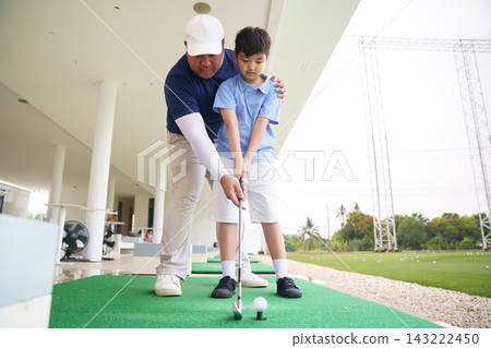 Professional golf coach guiding young student ball address position Professional golf coach guiding young student ball address position 143222450