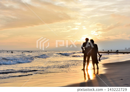 夕陽映照著久沼海灘上一對情侶的剪影。 夕陽映照著久沼海灘上一對情侶的剪影。 143222729
