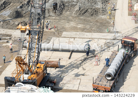 此作業涉及使用履帶式起重機在大型建築物的地基施工現場吊裝預製混凝土樁。 此作業涉及使用履帶式起重機在大型建築物的地基施工現場吊裝預製混凝土樁。 143224229