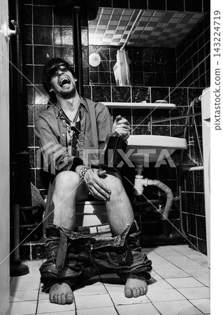 Intoxicated Man Laughing Wildly with Bottle on Toilet Intoxicated Man Laughing Wildly with Bottle on Toilet 143224719
