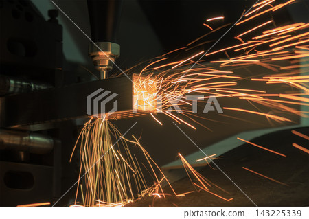 Splashing fire sparks from a laser cutting machine during a square metal tube cutting process Splashing fire sparks from a laser cutting machine during a square metal tube cutting process 143225339