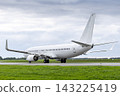 White passenger airliner taxiing at the taxiway at the airport in cloudy weather 143225419