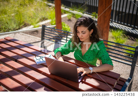 Caucasian woman working with laptop computer outside office. Caucasian woman working with laptop computer outside office. 143225438
