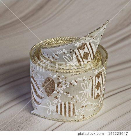 Close Up Of White Christmas Gift Wrapping Ribbon With Gold Pattern Close Up Of White Christmas Gift Wrapping Ribbon With Gold Pattern 143225647
