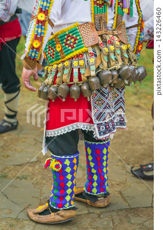 Kukeri Cowbells, Traditional Bulgarian Folk Costume Detail. Close view of Kukeri costume, heavy cowbells, leather belts, beadwork, embroidery, leg coverings. Craftsmanship, Bulgarian folklore clothing Kukeri Cowbells, Traditional Bulgarian Folk Costume Detail. Close view of Kukeri costume, heavy cowbells, leather belts, beadwork, embroidery, leg coverings. Craftsmanship, Bulgarian folklore clothing 143226460