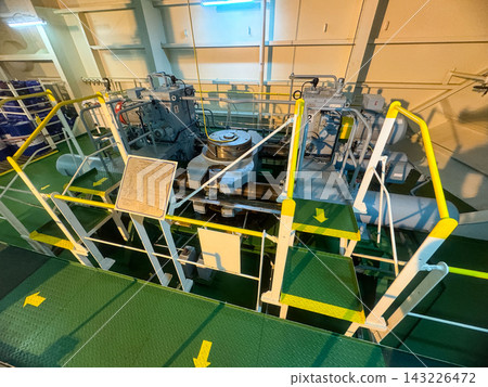 Industrial interior of a ship steering gear room featuring heavy electro hydraulic plunger type system layout. Industrial interior of a ship steering gear room featuring heavy electro hydraulic plunger type system layout. 143226472