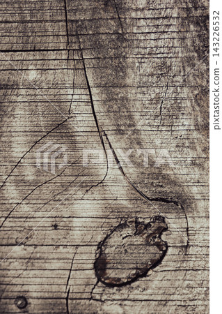 Weathered wooden surface displaying deep cracks and a prominent knot, creating a natural texture and rustic background pattern ideal for design projects. Weathered wooden surface displaying deep cracks and a prominent knot, creating a natural texture and rustic background pattern ideal for design projects. 143226532