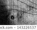 Aged wood plank surface showing deep cracks and a prominent knot, creating a rustic and weathered texture in a monochromatic black and white aesthetic for backgrounds 143226537