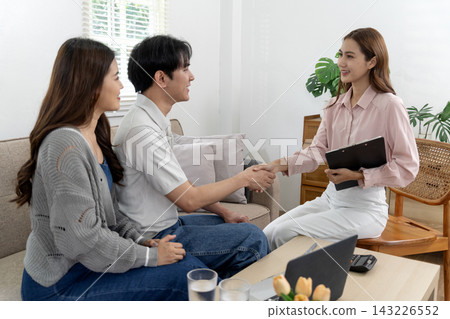 Asian Real Estate Agent Shaking Hands with Young Couple After Successful Home Buying Consultation Asian Real Estate Agent Shaking Hands with Young Couple After Successful Home Buying Consultation 143226552