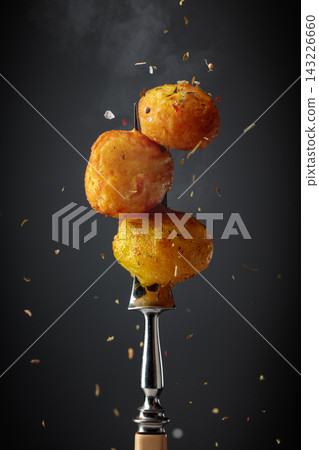 Roasted potatoes sprinkled with a mixture of herbs and spices. Roasted potatoes sprinkled with a mixture of herbs and spices. 143226660