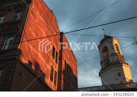 Historic clock tower of Vyborg old town rises beside a red brick building Historic clock tower of Vyborg old town rises beside a red brick building 143226820