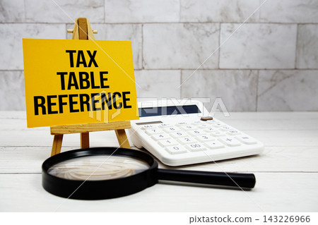 Tax Table Reference text with calculator and magnifying glass Tax Table Reference text with calculator and magnifying glass 143226966