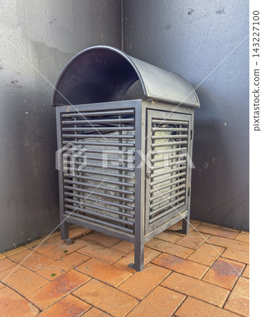 A rubbish bin on a brick footpath at a commercial shopping centre A rubbish bin on a brick footpath at a commercial shopping centre 143227100