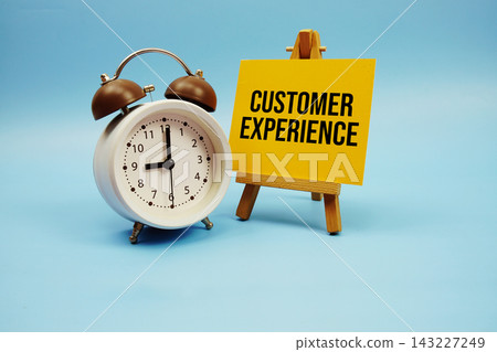 Customer Experience text written on paper card and alarm clock on blue background Customer Experience text written on paper card and alarm clock on blue background 143227249